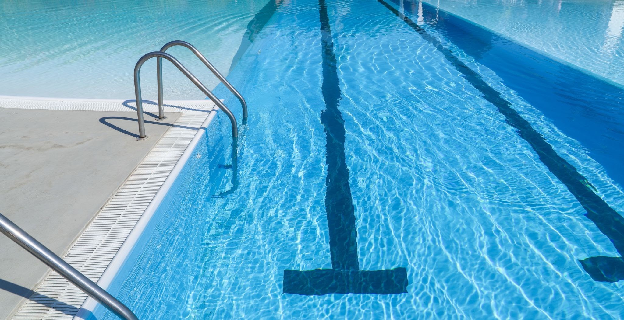 swimming pool with blue water and sun reflections. swimming pool background